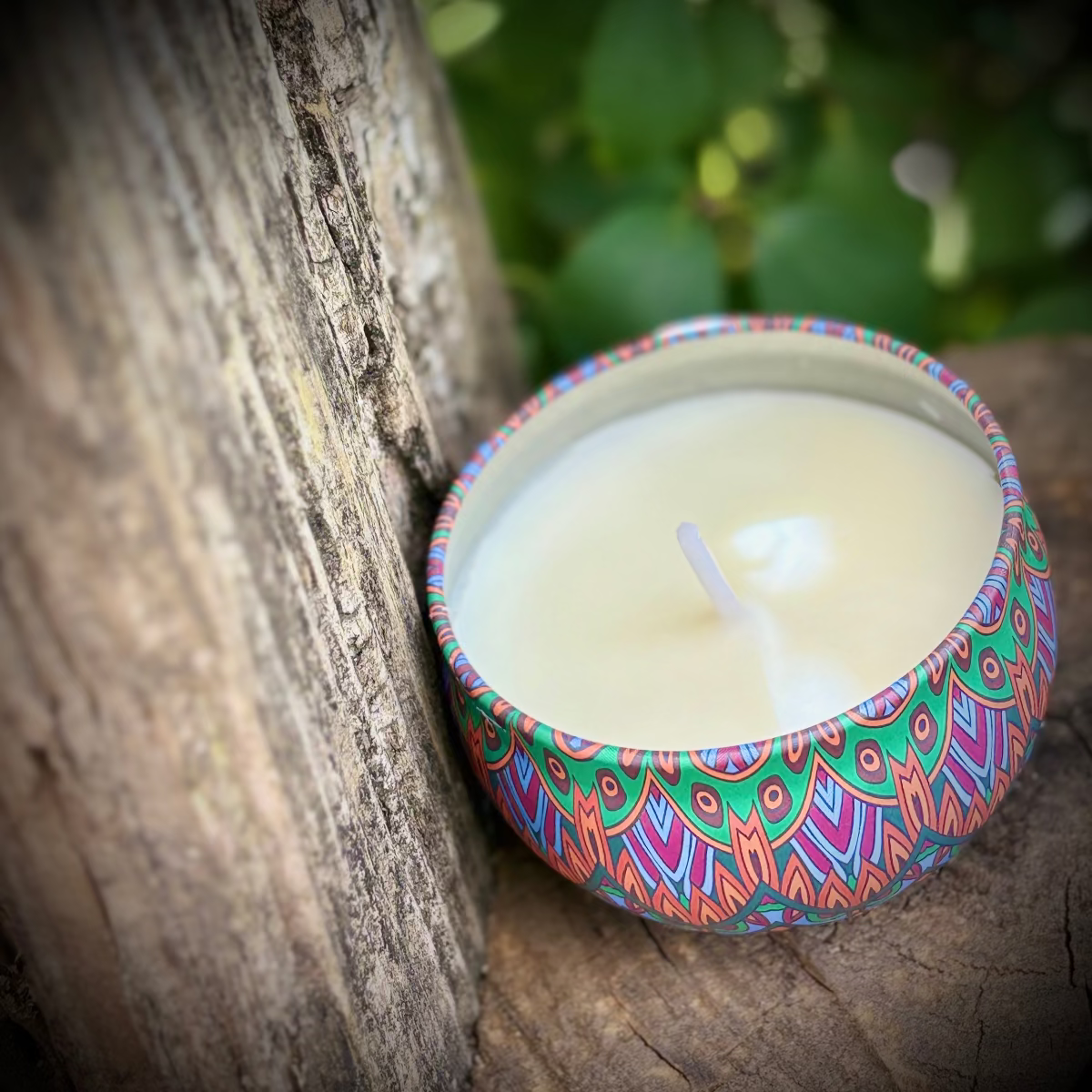 Decorative candle with a colorful pattern on a wooden surface