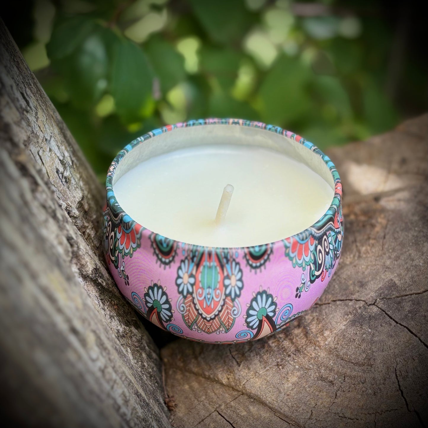Decorative candle with a colorful pattern on a wooden surface