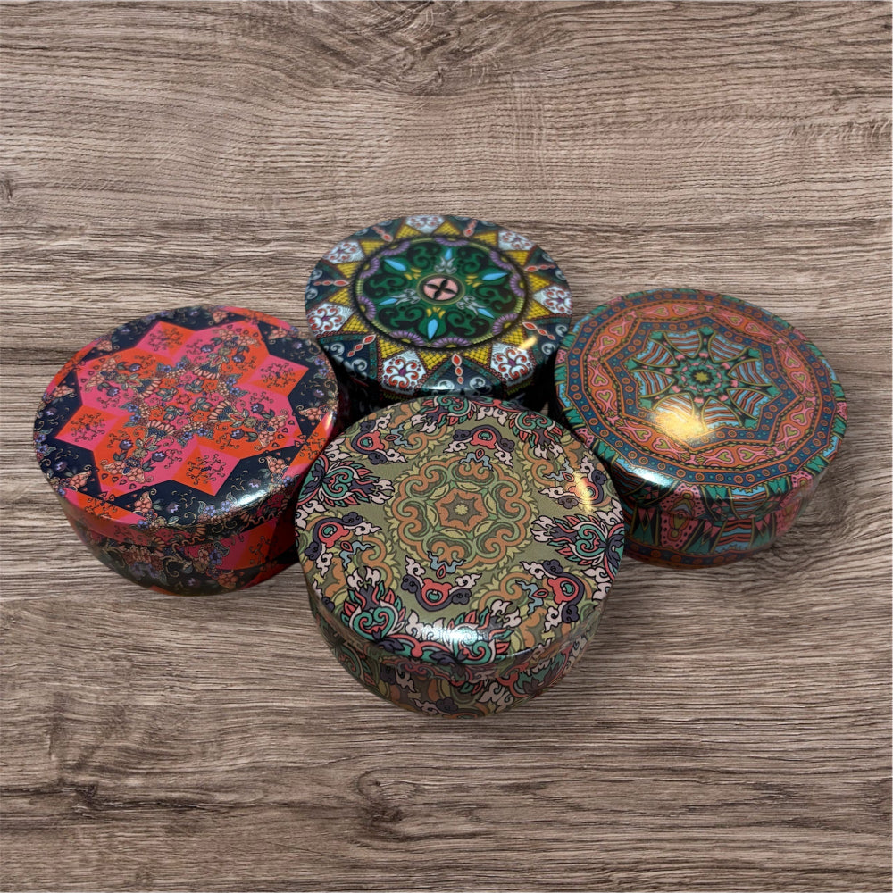Four decorative boxes with intricate patterns on a wooden surface