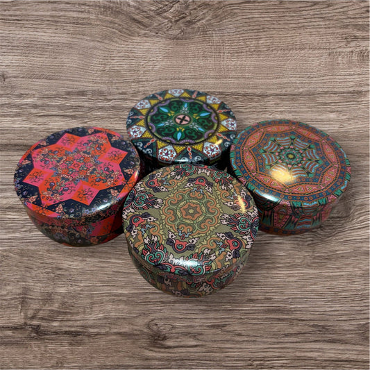 Four decorative boxes with intricate patterns on a wooden surface