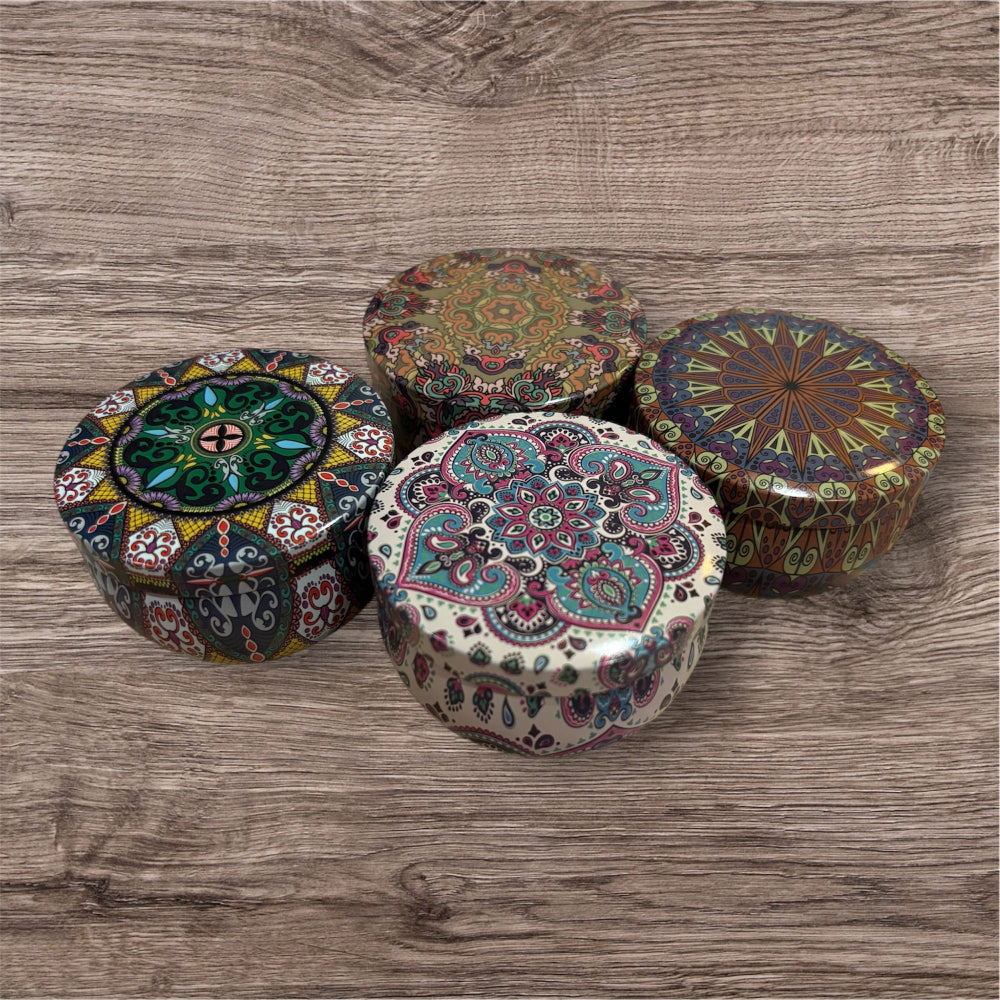 Four decorative boxes with intricate patterns on a wooden surface